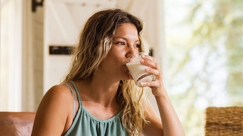 Woman sipping from a cup of milk