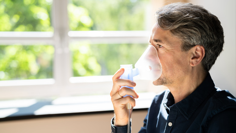 man use breathing nebulizer