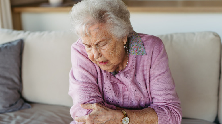 Woman in pain holding her elbow