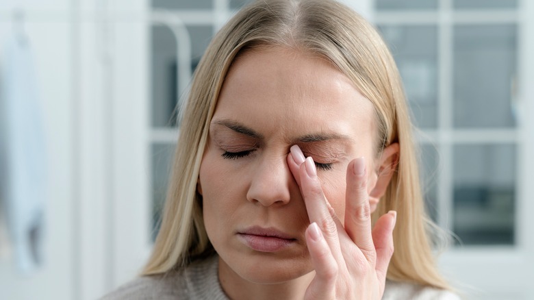 Woman clutching her head in exhaustion