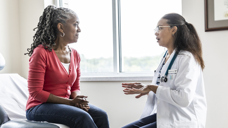 Woman talking to her doctor in exam room