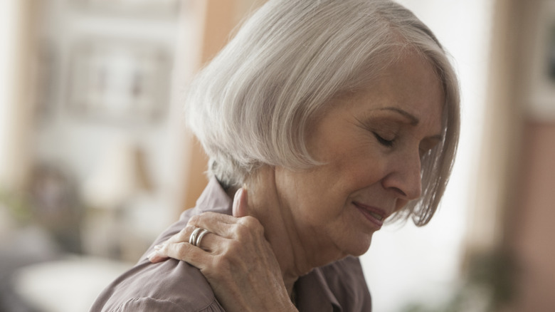 Woman clutching her shoulder in pain