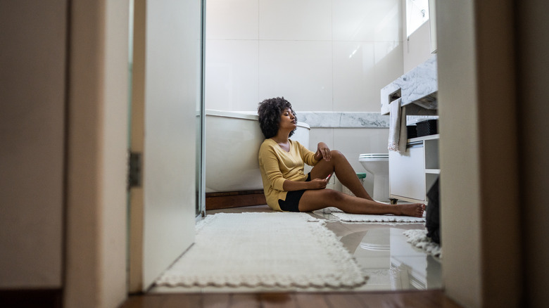 woman sitting on bathroom floor