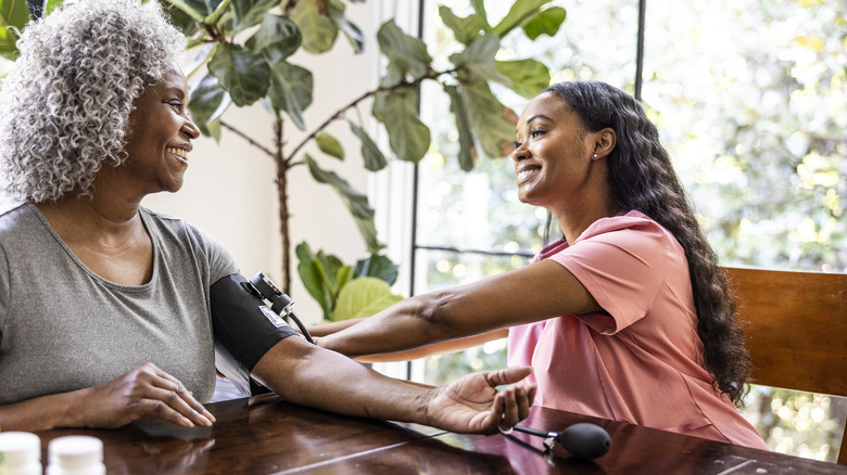 healthcare worker checking patient blood pressure