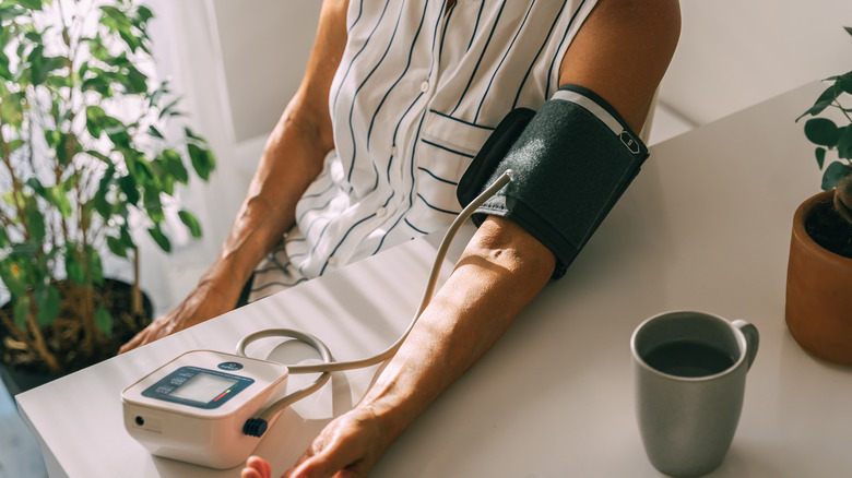 woman checking blood pressure on monitor at home