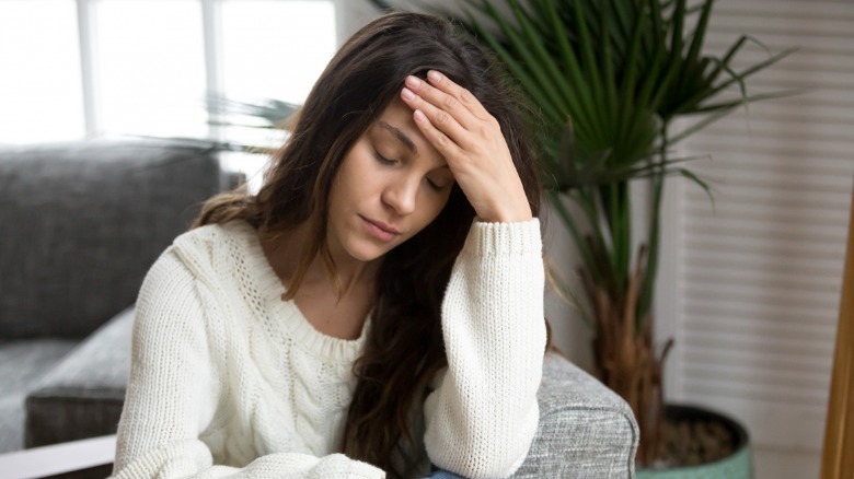 woman seated feels dizzy