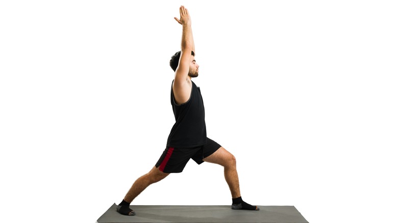 man doing warrior 1 yoga pose