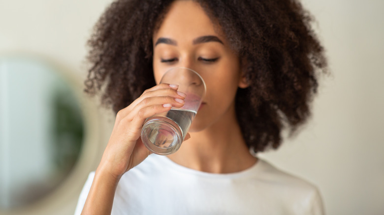 young woman drinking a glass of water