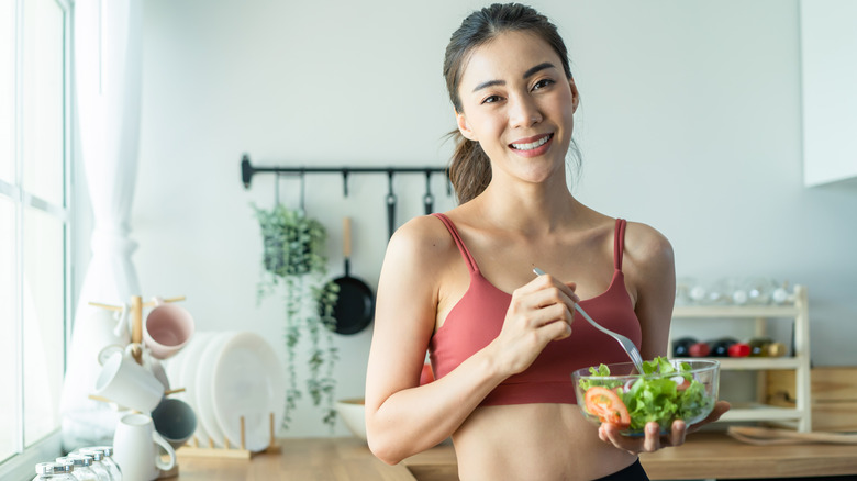 Asian woman eating salad