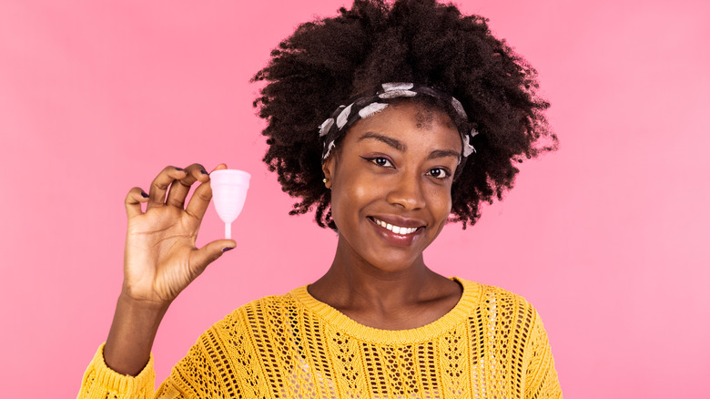 Smiling woman holding menstrual cup