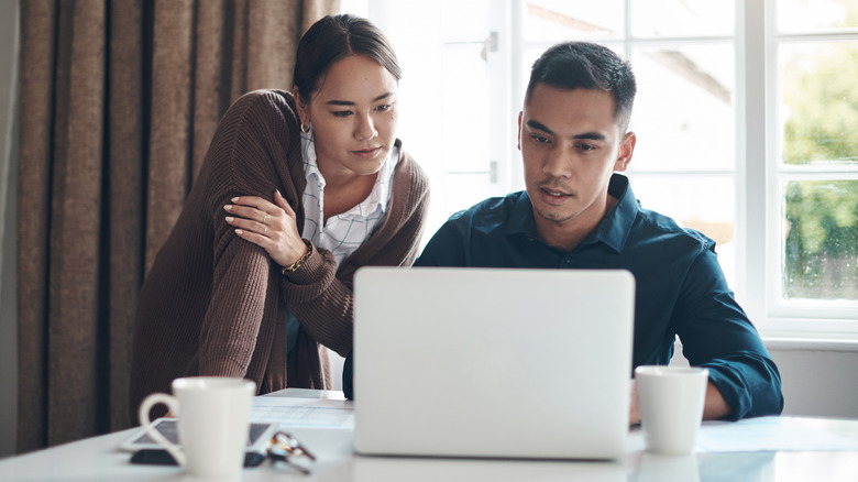 A couple conducting research on their laptop