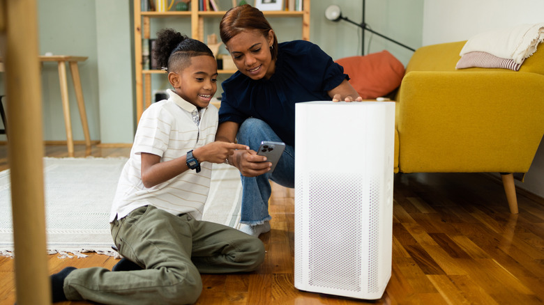 A mom and son setting up an air purifier in home