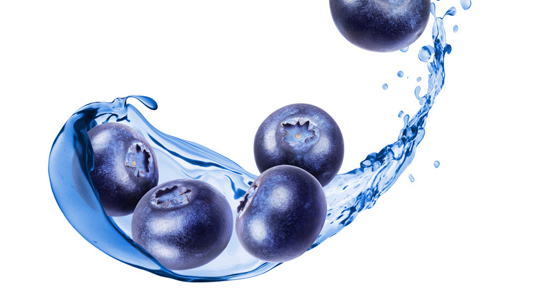 blueberries splashing with blue water