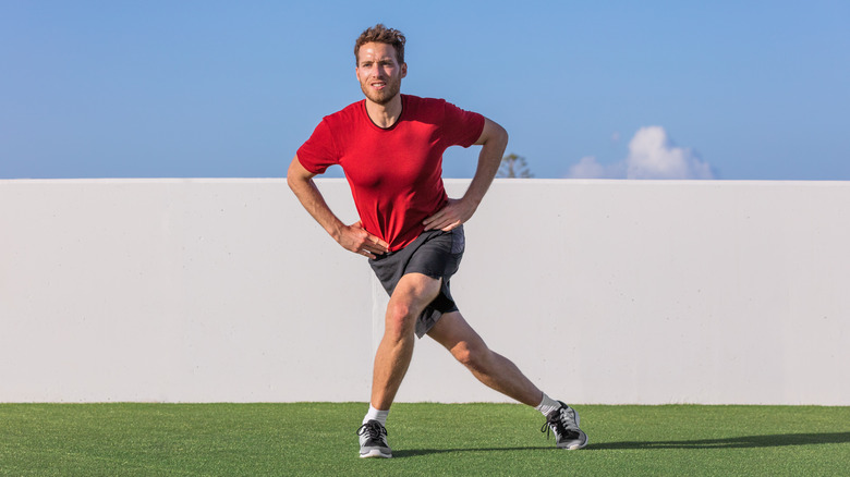 Man doing a curtsy lunge outdoors