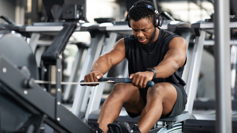 athletic man pulling on rowing machine