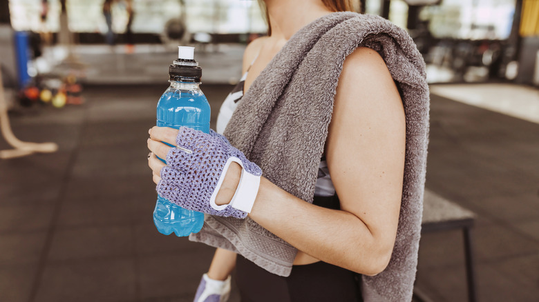 woman holding sports drink to consume after workout
