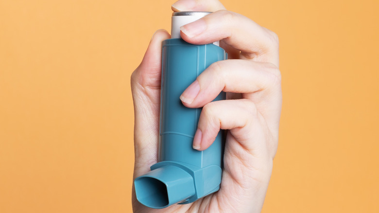 person holding asthma inhaler