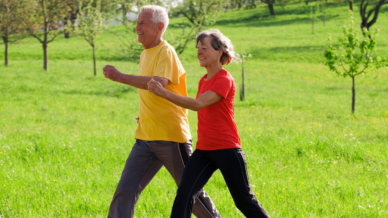 Man and woman power walking through field