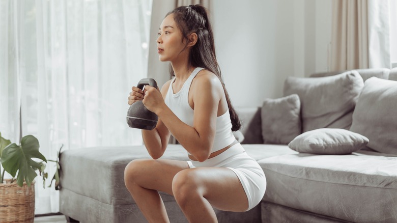 Woman doing squats with kettlebell