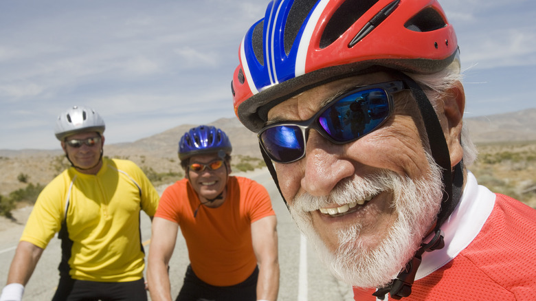 closeup of mature men in bicycle helmets