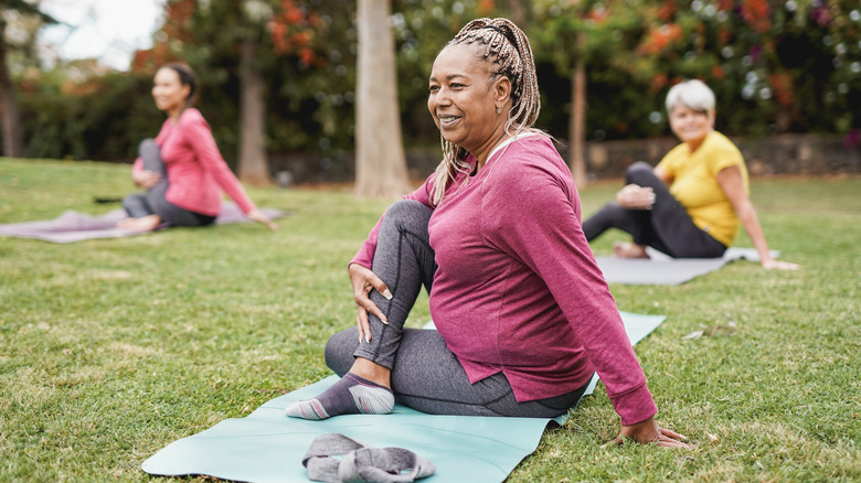 women on outdoor mats in a yoga pose