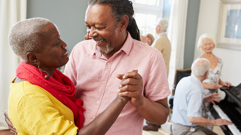 laughing couple holding hands while dancing