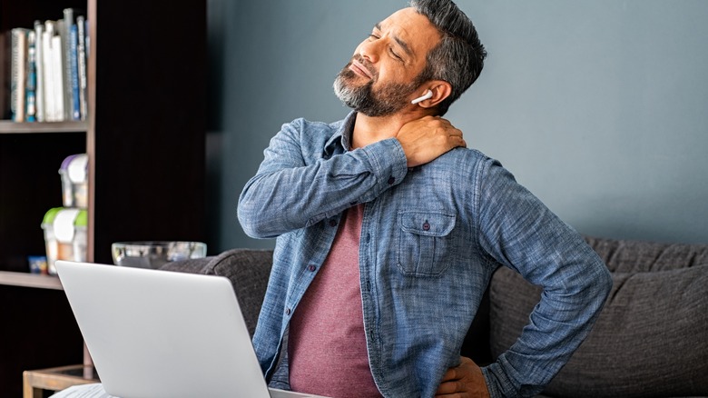 Man with shoulder pain at laptop 