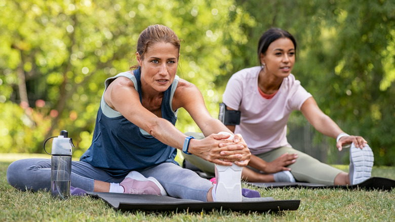 Woman stretching legs in park