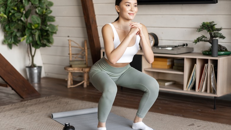 Woman doing squats at home