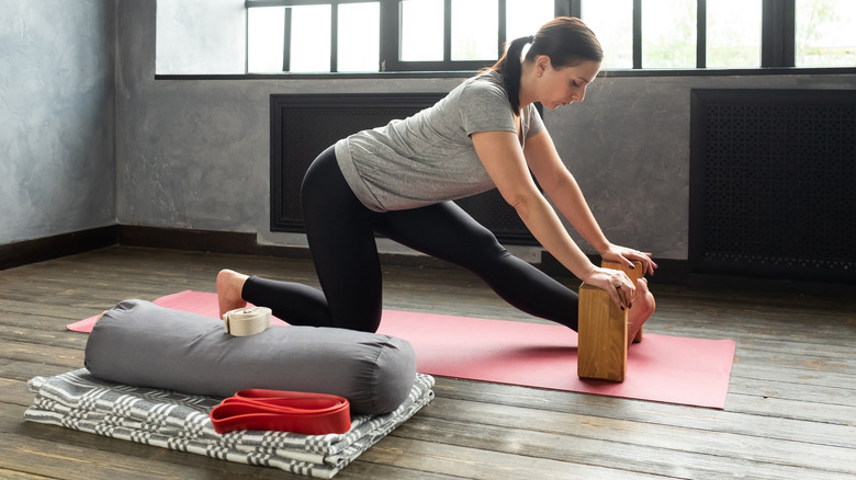 woman practicing yoga with assistance of yoga props