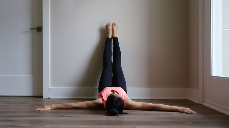 woman relaxing into legs up wall pose