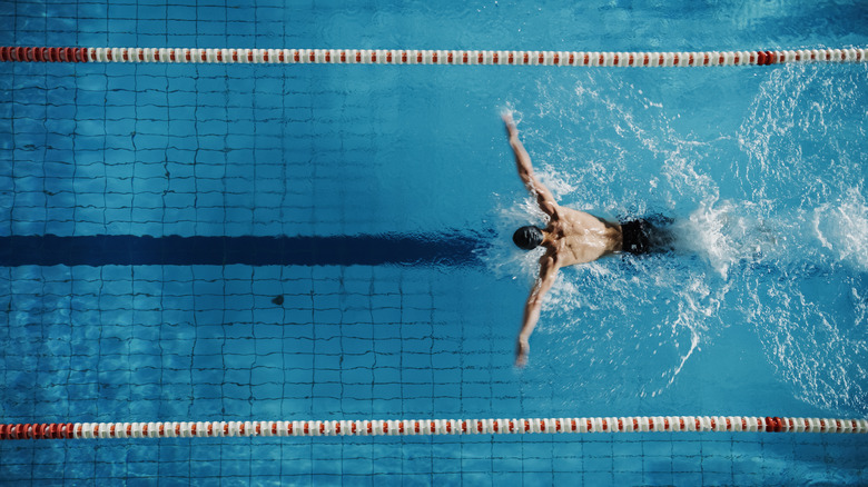 man swimming in indoor pool