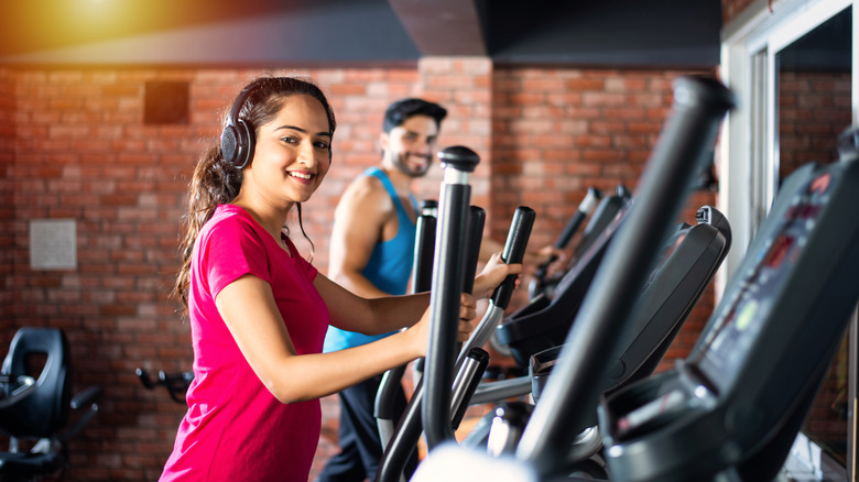 couple working out on ellipticals