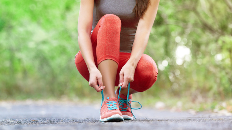 woman lacing up sneakers