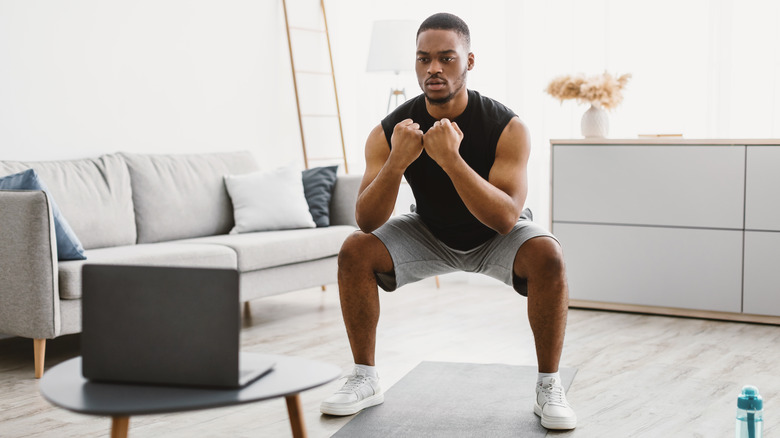 man doing squats at home