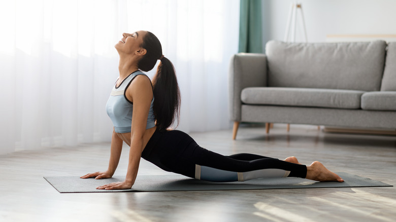 A woman does yoga in her living room