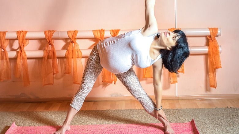 Pregnant woman doing triangle pose