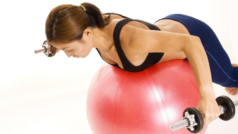 Woman on exercise ball doing reverse fly