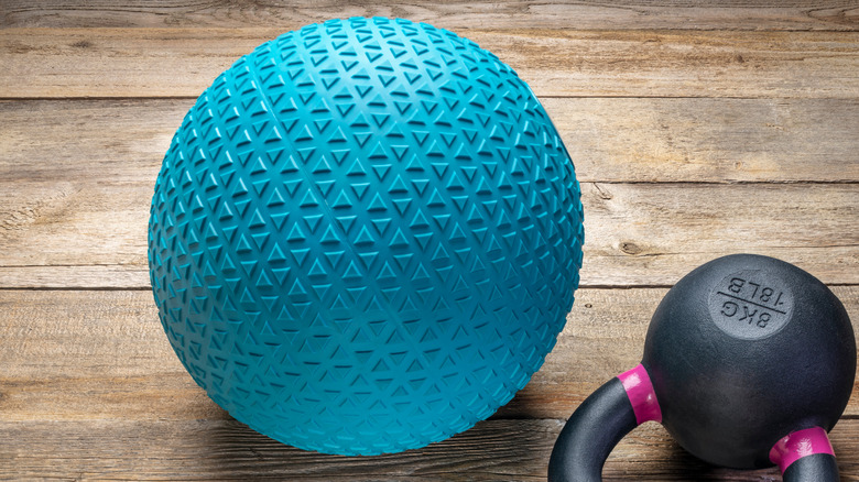 Medium-sized exercise ball next to a kettlebell 
