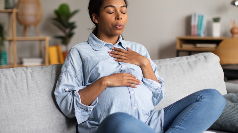 pregnant woman breathing on the couch 