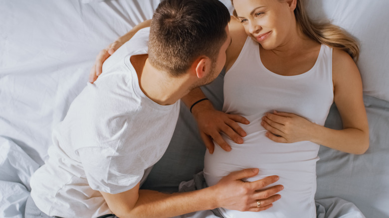 pregnant woman in bed with partner 