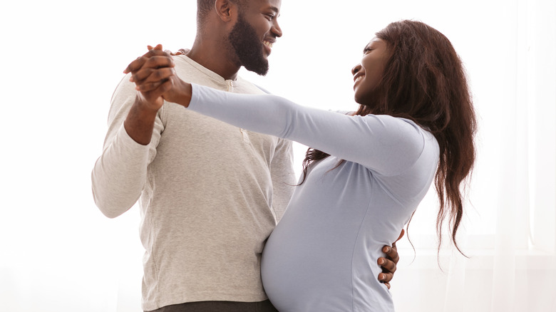 pregnant woman dancing with partner