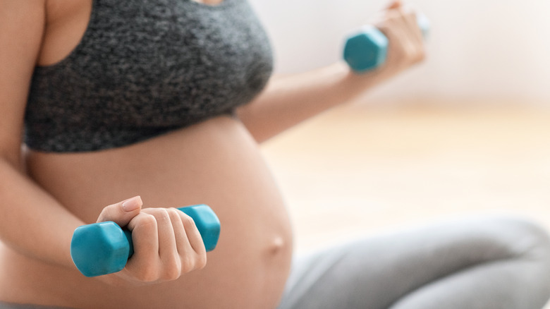 pregnant woman exercising with weights