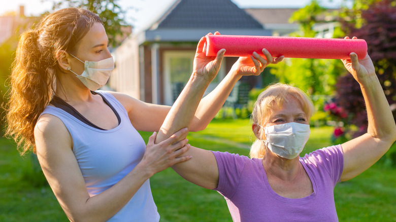 woman doing exercise with healthcare professional