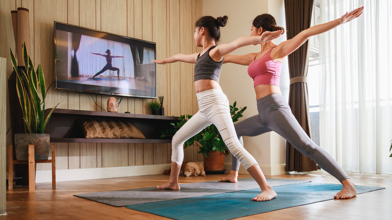 Two women doing yoga at home