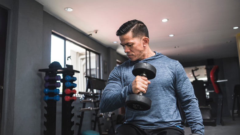 man doing hammer curls in gym