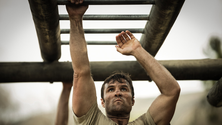 man swinging on monkey bars