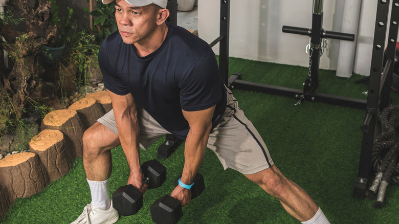 man doing dumbbell side lunge