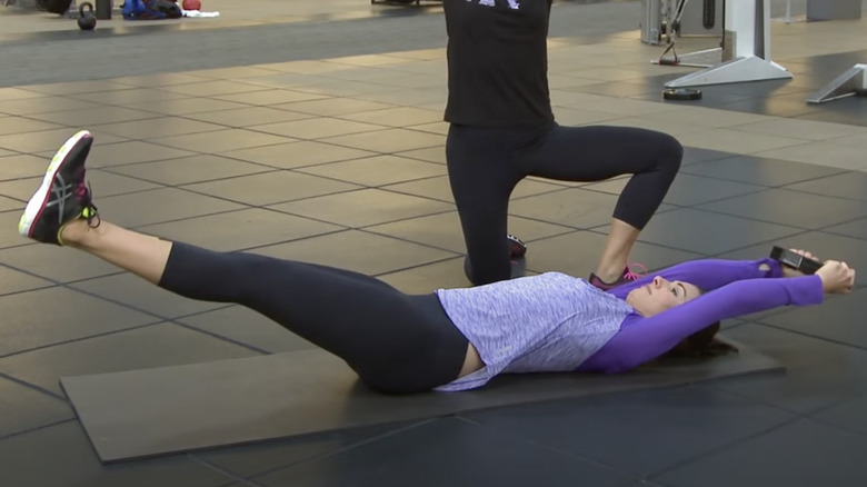 woman doing weighted suitcase crunch