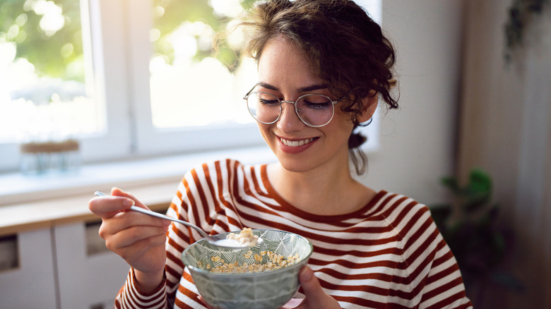 Smiling woman eating oatmeal